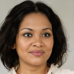 Joyful latino adult female with medium  brown hair and brown eyes