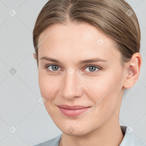 Joyful white young-adult female with medium  brown hair and grey eyes