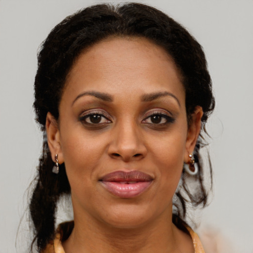 Joyful black adult female with long  brown hair and brown eyes