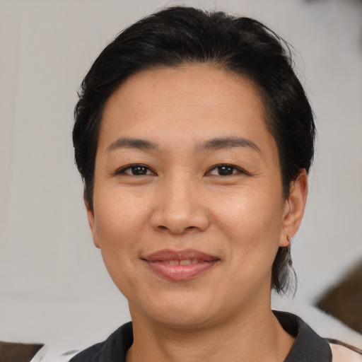 Joyful latino adult female with medium  brown hair and brown eyes