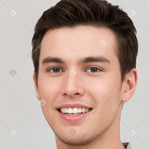 Joyful white young-adult male with short  brown hair and brown eyes