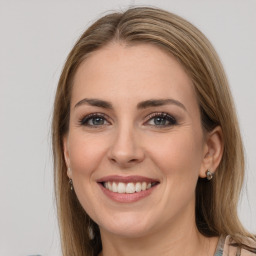 Joyful white young-adult female with long  brown hair and grey eyes