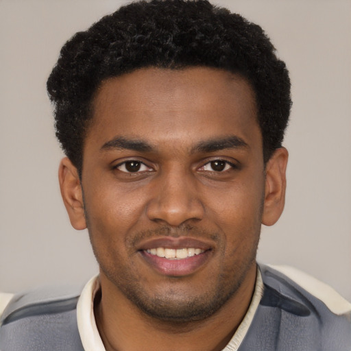 Joyful black young-adult male with short  brown hair and brown eyes