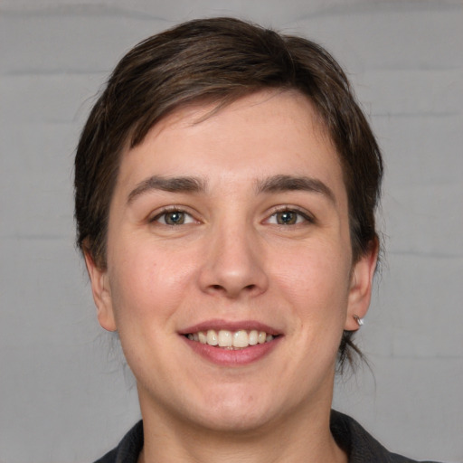 Joyful white young-adult male with medium  brown hair and grey eyes