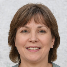 Joyful white adult female with medium  brown hair and grey eyes