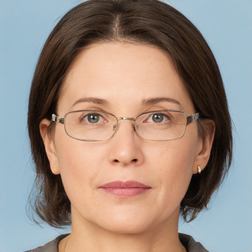 Joyful white adult female with medium  brown hair and grey eyes