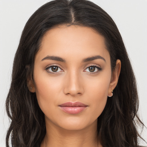 Joyful latino young-adult female with long  brown hair and brown eyes