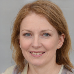 Joyful white adult female with medium  brown hair and blue eyes