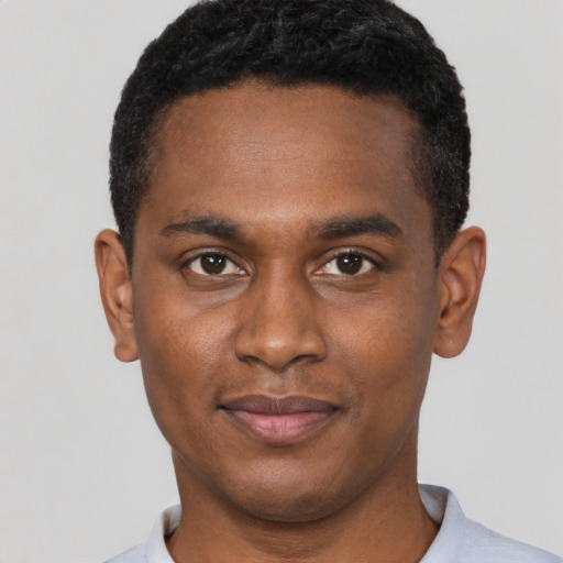 Joyful black young-adult male with short  black hair and brown eyes