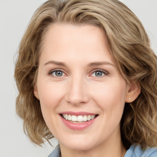 Joyful white young-adult female with medium  brown hair and blue eyes