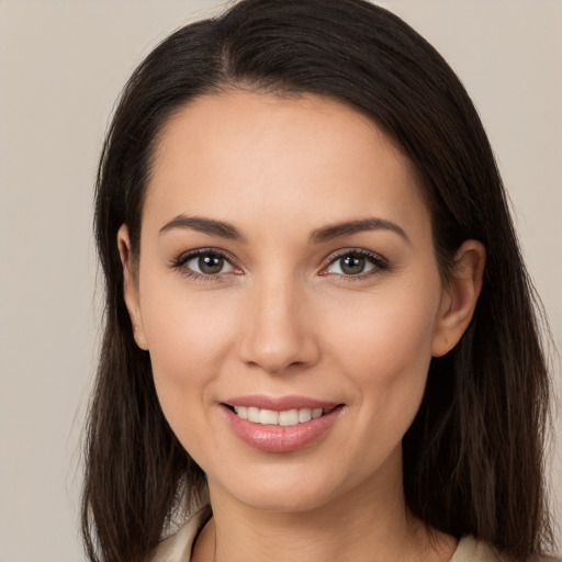 Joyful white young-adult female with long  brown hair and brown eyes