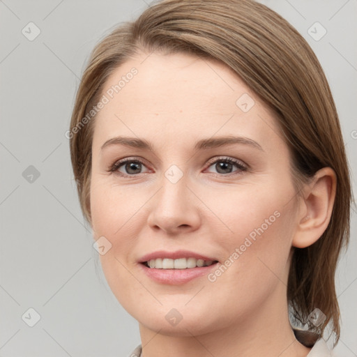 Joyful white young-adult female with medium  brown hair and grey eyes