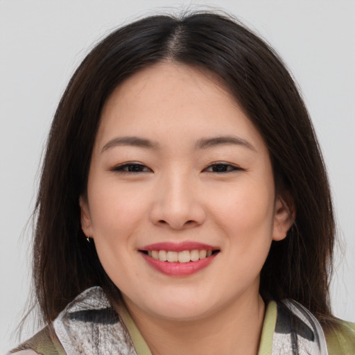 Joyful asian young-adult female with medium  brown hair and brown eyes
