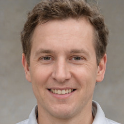 Joyful white adult male with short  brown hair and grey eyes