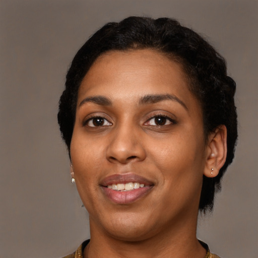 Joyful black young-adult female with short  black hair and brown eyes
