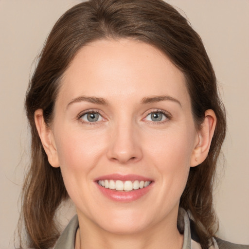 Joyful white young-adult female with medium  brown hair and grey eyes