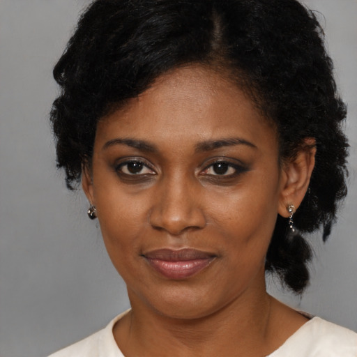 Joyful black young-adult female with medium  black hair and brown eyes