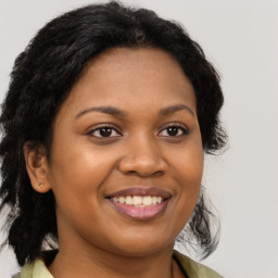 Joyful black young-adult female with long  brown hair and brown eyes