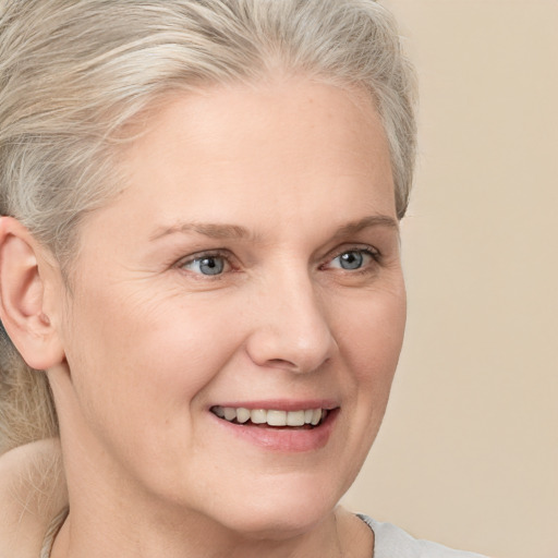 Joyful white adult female with medium  blond hair and grey eyes