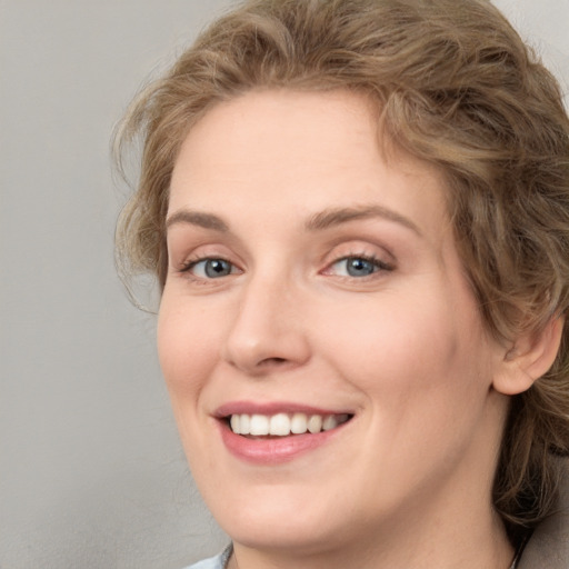 Joyful white young-adult female with medium  brown hair and blue eyes