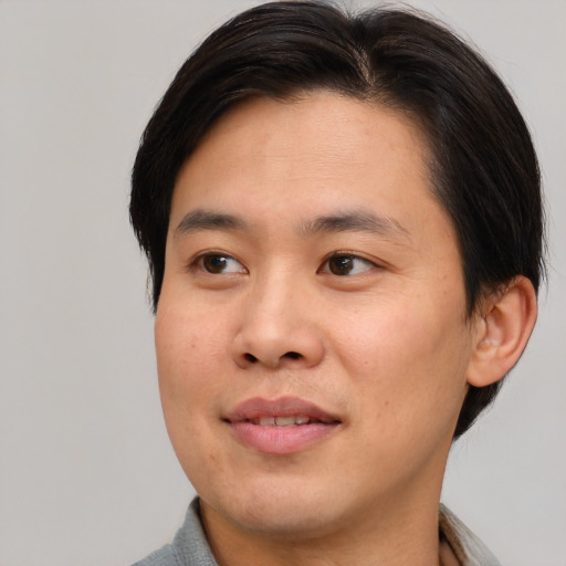 Joyful asian young-adult male with medium  brown hair and brown eyes