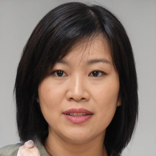 Joyful asian adult female with medium  brown hair and brown eyes