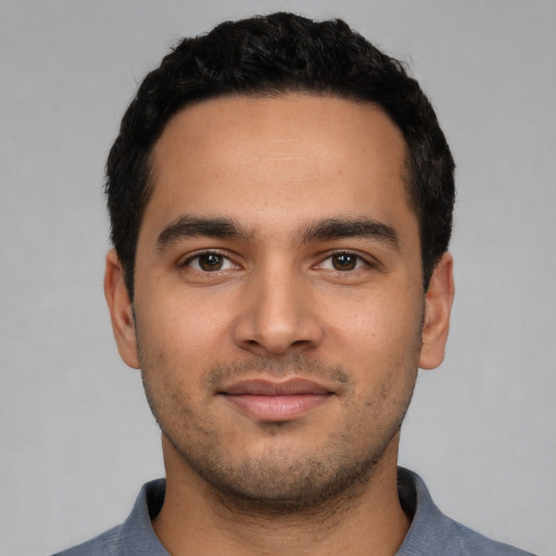 Joyful latino young-adult male with short  black hair and brown eyes