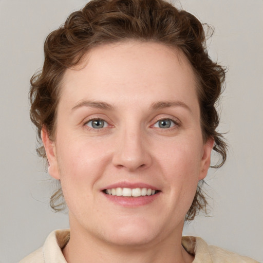 Joyful white young-adult female with medium  brown hair and blue eyes