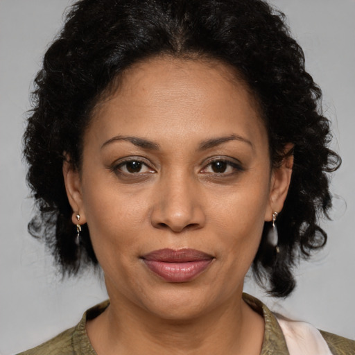 Joyful latino adult female with medium  brown hair and brown eyes
