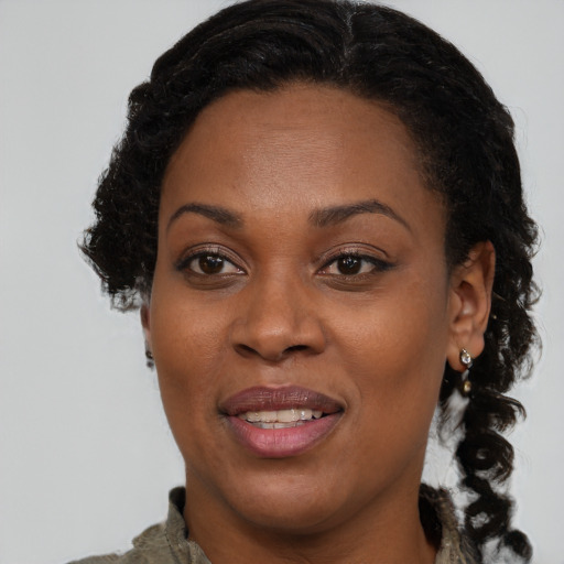 Joyful black adult female with medium  brown hair and brown eyes