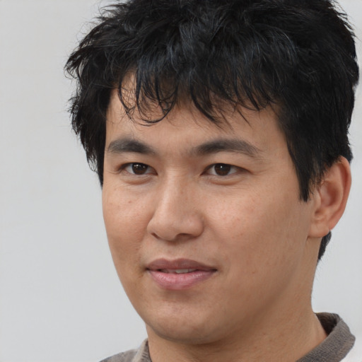 Joyful asian young-adult male with short  brown hair and brown eyes