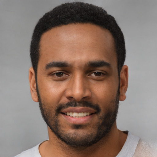 Joyful black young-adult male with short  black hair and brown eyes