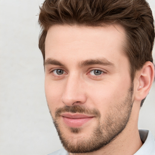 Joyful white young-adult male with short  brown hair and grey eyes