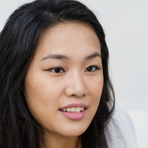 Joyful asian young-adult female with long  brown hair and brown eyes