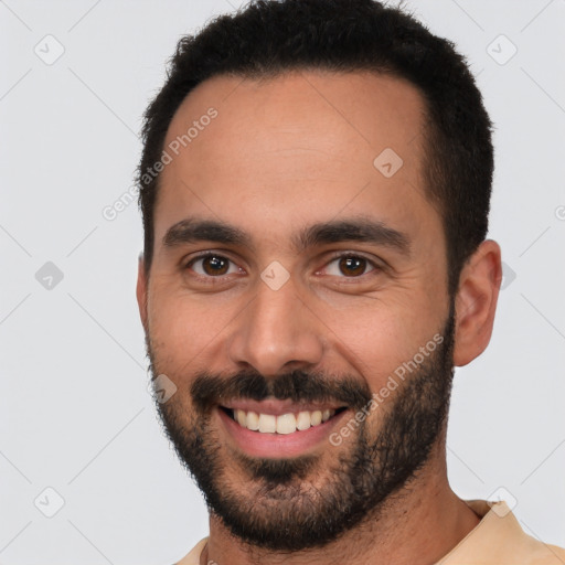 Joyful white young-adult male with short  black hair and brown eyes