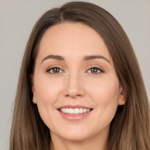 Joyful white young-adult female with long  brown hair and brown eyes