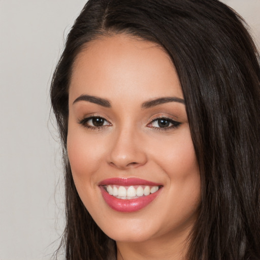 Joyful white young-adult female with long  black hair and brown eyes