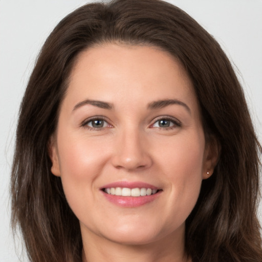 Joyful white young-adult female with long  brown hair and brown eyes