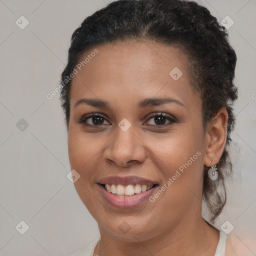 Joyful black young-adult female with short  brown hair and brown eyes