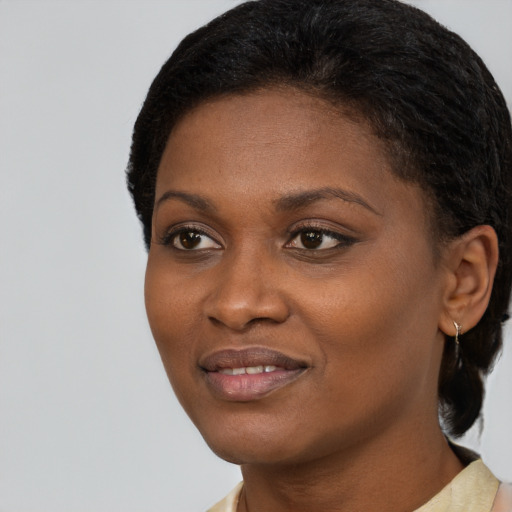 Joyful black young-adult female with short  black hair and brown eyes