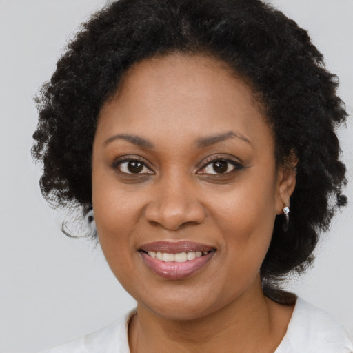 Joyful black young-adult female with medium  brown hair and brown eyes