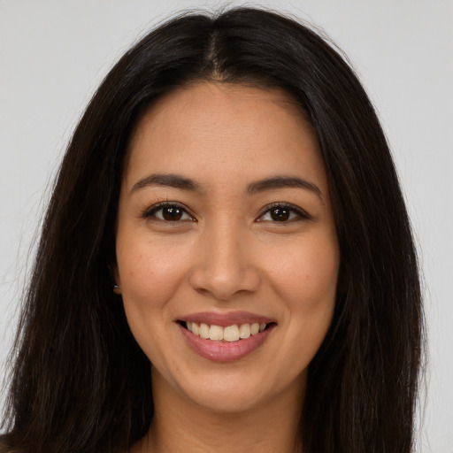 Joyful latino young-adult female with long  brown hair and brown eyes