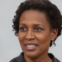 Joyful black adult female with medium  brown hair and brown eyes