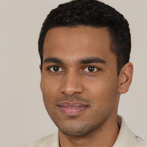 Joyful black young-adult male with short  black hair and brown eyes