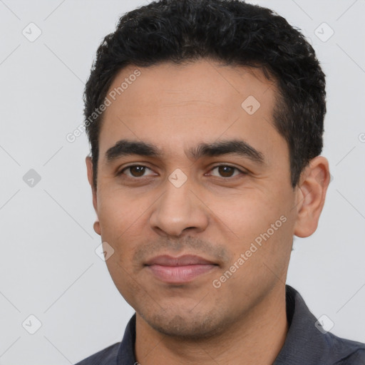 Joyful latino young-adult male with short  black hair and brown eyes