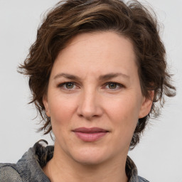 Joyful white adult female with medium  brown hair and grey eyes