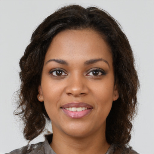 Joyful black young-adult female with medium  brown hair and brown eyes