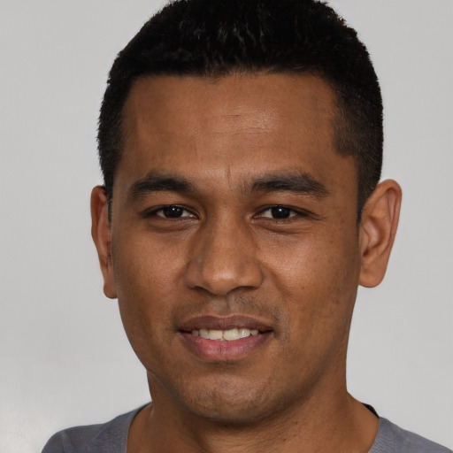 Joyful white young-adult male with short  black hair and brown eyes