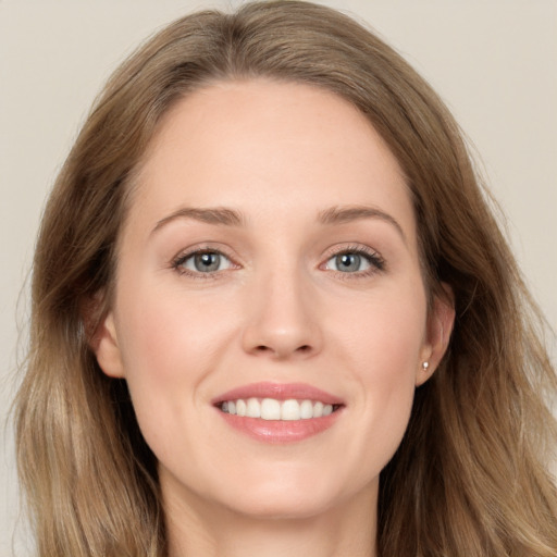 Joyful white young-adult female with long  brown hair and blue eyes