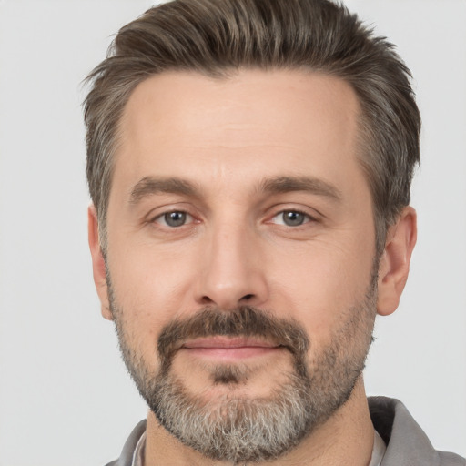 Joyful white adult male with short  brown hair and brown eyes